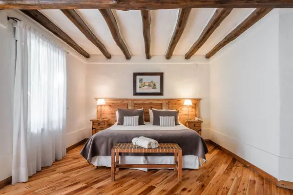 Habitación Clásica con cama doble, vigas de madera a la vista y piso de madera