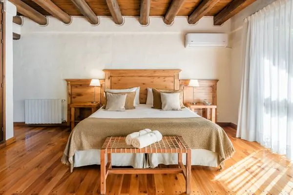 Habitación Superior con cama doble, vigas de madera y luz natural
